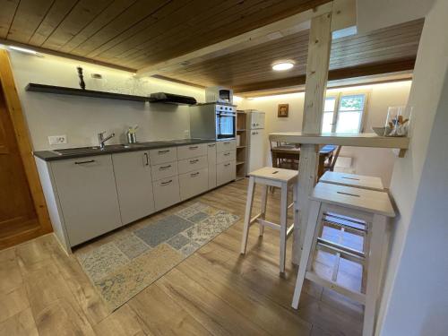 a kitchen with a sink and a counter with a stool at Apartment Alpenchalet Haldeli by Interhome in Gstaad