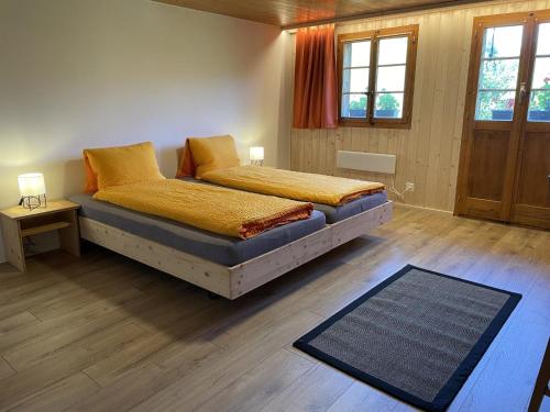 a bedroom with two beds and a rug at Apartment Alpenchalet Haldeli by Interhome in Gstaad
