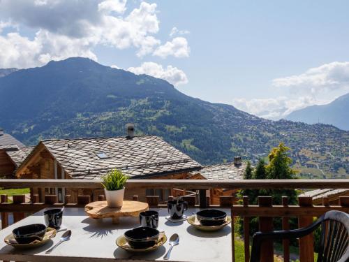 a table with plates of food on a balcony with mountains at Studio Beau Soleil G11 by Interhome in Veysonnaz