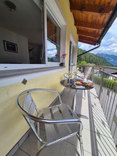 a chair sitting on a balcony with a table at Appartementhaus Flattach Goritschnig in Flattach