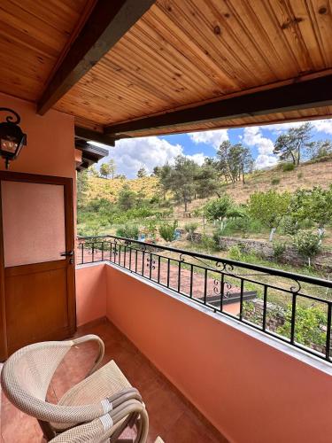 a balcony with a chair and a view of a field at Zholi Guest House in Gjirokastër