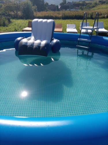 a swimming pool with two chairs in the water at Sadyba u Vani in Volovets