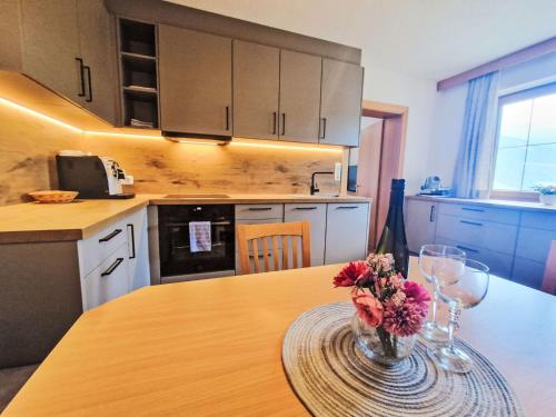 a kitchen with a table with a vase of flowers on it at Apartment Dinkl by Interhome in Stummerberg