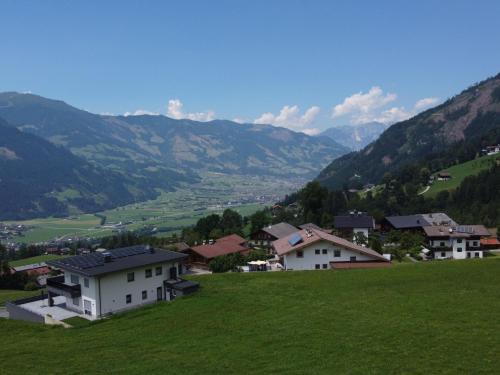 a group of houses on a green hill with mountains at Apartment Dinkl by Interhome in Stummerberg