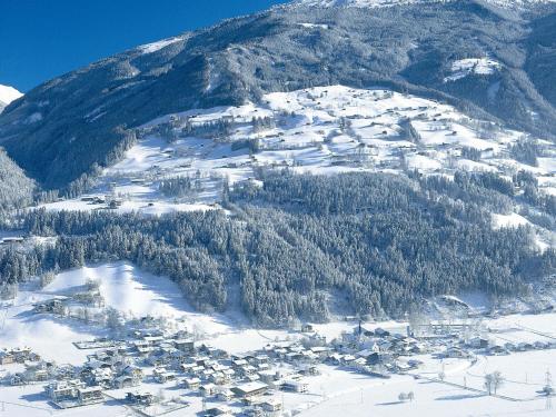 a snow covered mountain with houses and trees on it at Apartment Dinkl by Interhome in Stummerberg