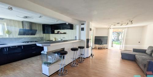 une cuisine et un salon avec un comptoir et des tabourets dans l'établissement Maison blanche, à Signes