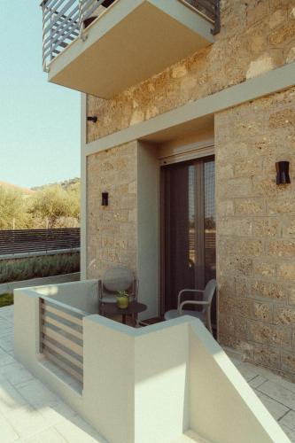 a house with a balcony with a table and chairs at Ollenia's Harmony Luxury Apartments in Derveni