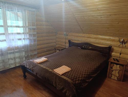 a bedroom with a bed in a log cabin at Лісовик in Synevyrsʼka Polyana