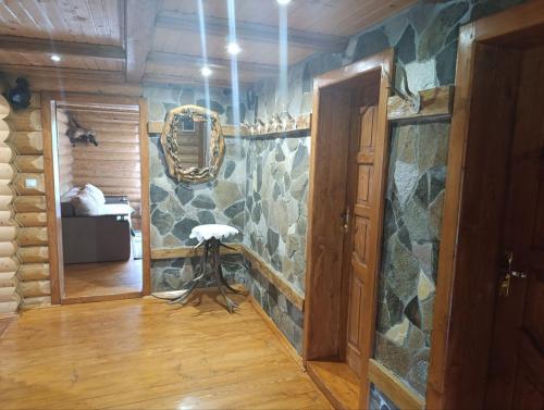 a room with a stone wall with a mirror at Лісовик in Synevyrsʼka Polyana