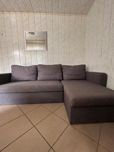 a couch sitting in a room with a wall at Holiday - domek letniskowy 2 in Charzykowy