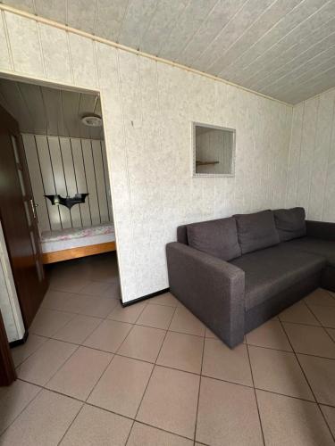 a living room with a couch and a window at Holiday - domek letniskowy 2 in Charzykowy