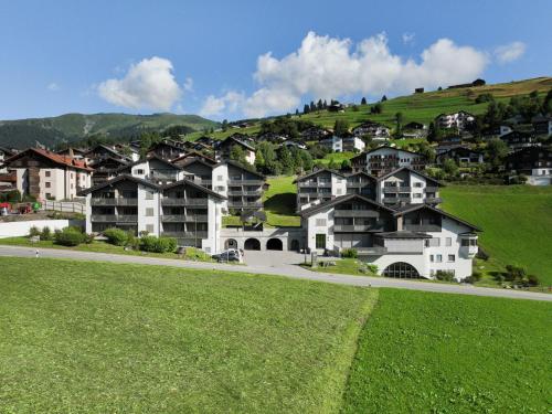a group of houses on a hill with a green field at Apartment La Siala Apt-70 by Interhome in Falera