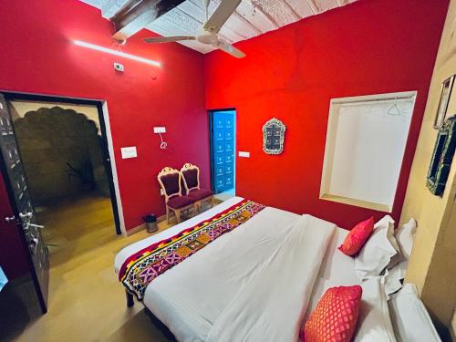 a bedroom with red walls and a bed with red pillows at Hotel Amazing Jaisalmer in Jaisalmer