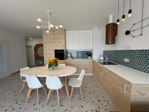 a kitchen with a table and chairs and a kitchen with blue tiles at Sweet Home Apartament in Przechlewo