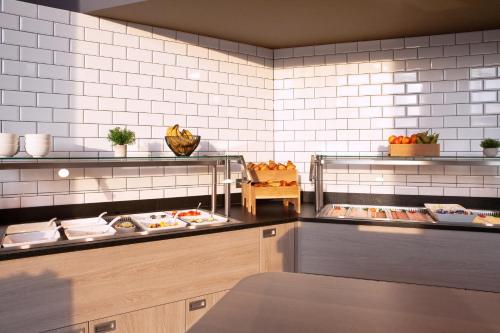 a restaurant kitchen with food items on display at Holiday Inn Express & Suites Monheim am Rhein by IHG in Monheim