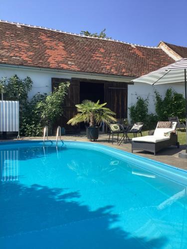 a blue swimming pool in front of a house at Bed & Breakfast Chez Lips in Oberbildein