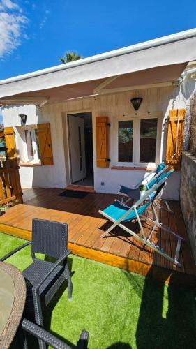 une terrasse avec deux chaises longues et une maison dans l'établissement La petite Luciole entre mer et montagne., à Cagnes-sur-Mer