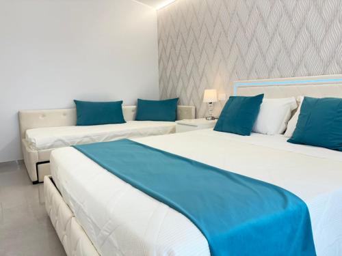 two beds in a room with blue and white at Ranieri Guest House in Celano