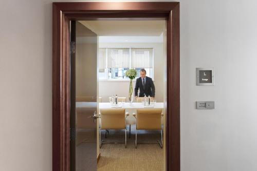 a man in a suit is sitting at a table at COMO Metropolitan London in London