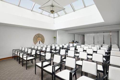 an empty room with rows of white chairs at COMO Metropolitan London in London