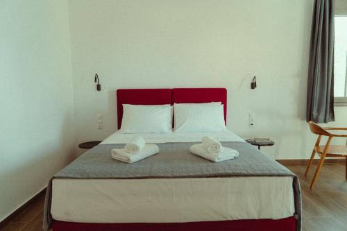 a bedroom with a large bed with two towels on it at Ollenia's Harmony Luxury Apartments in Derveni