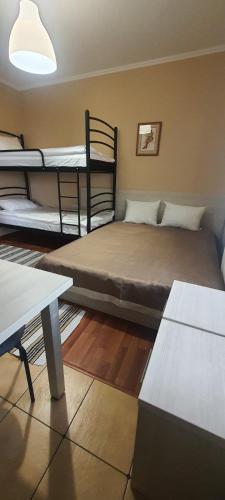 a room with three bunk beds and a table at Tulipan Hotel Aquapark in Vyshkove
