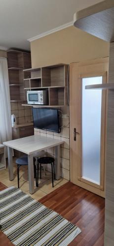 a kitchen with a table and a microwave on a wall at Tulipan Hotel Aquapark in Vyshkove