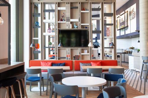 a restaurant with orange and blue chairs and tables at Holiday Inn Express & Suites Monheim am Rhein by IHG in Monheim
