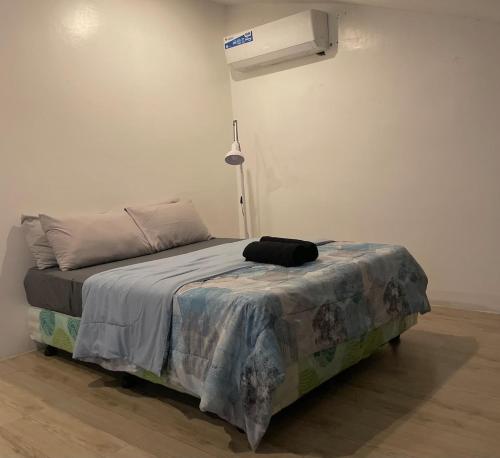 a bedroom with a bed with a blanket on it at Affordable Family Loft Condo near Mactan Airport by A&C in Mactan Cebu International