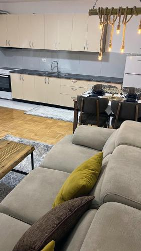a living room with a couch and a kitchen at Shala Apartments in Prizren