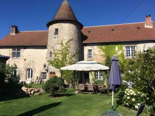 an umbrella in the yard of a building at Chez Poton in Le Grand-Bourg