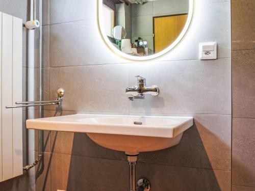 a bathroom with a sink and a mirror at Holiday Home Maison des Gorges by Interhome in Moutier