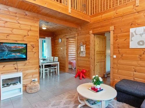 un salon avec des murs en bois et une télévision dans une cabane dans l'établissement Holiday Home Karhu by Interhome, à Savonranta