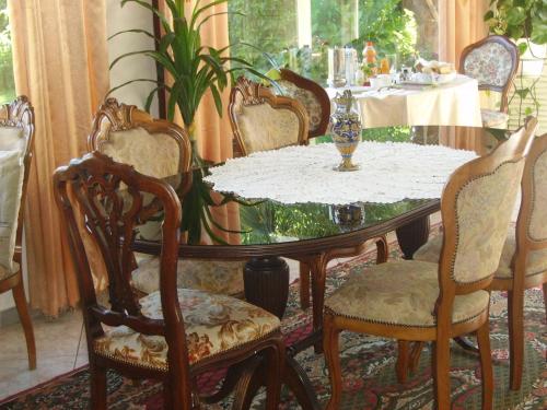 einem Esstisch mit Stühlen und einer Vase darauf in der Unterkunft B&B Madonna della Neve in Stresa