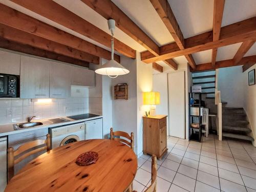 カルナックにあるApartment Les Reflets de Carnac-2 by Interhomeの木製のテーブルとダイニングルームのあるキッチン