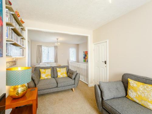a living room with two couches and a table at Russell Cottage in Alnwick