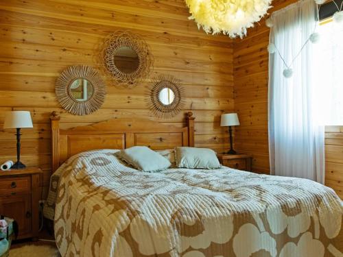 a bedroom with a bed and two mirrors on the wall at Holiday Home Kesäranta by Interhome in Alavus