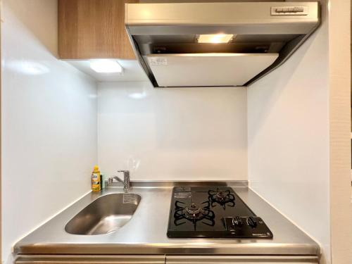 una cucina con fornelli e lavello di Otsuka No3 Mansion #JR Yamanote Line#Fixed Wifi a Tokyo