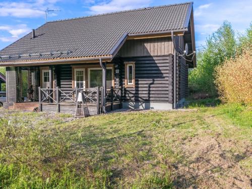 une maison en rondins avec une terrasse couverte et une cour dans l'établissement Holiday Home Ilves by Interhome, à Savonranta