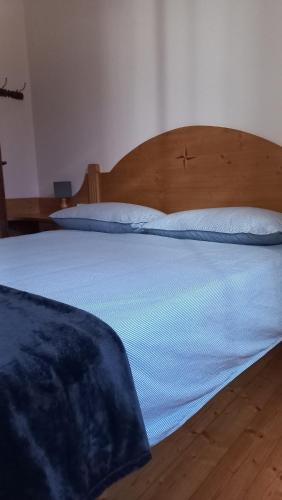 a bedroom with a large bed with a wooden headboard at Appartamento il Riccio in Pontebba