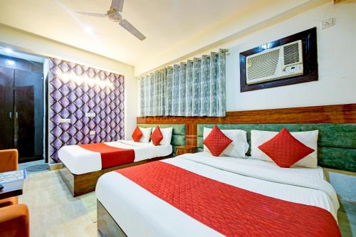 a hotel room with two beds and a desk at Hotel Sky View at Airport,New Delhi in New Delhi