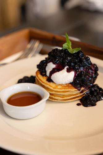 a plate with a stack of pancakes with blackberries and whipped cream at The Hoxton, Poblenou in Barcelona