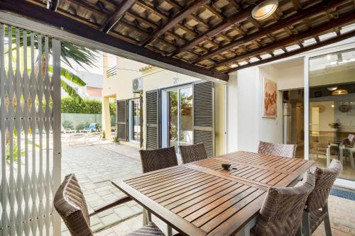 an outdoor dining room with a wooden table and chairs at Vila Sophia, Vilamoura- By Urbinvest Algarve in Vilamoura