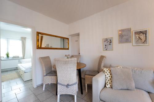 ein Wohnzimmer mit einer Couch und einem Tisch und Stühlen in der Unterkunft Reiterhof an der Nordsee in Witzwort