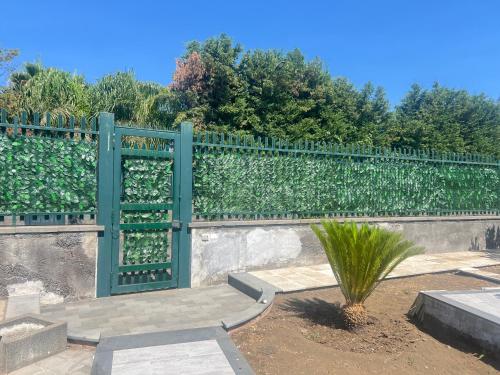 a green fence with a plant in front of it at Villa Leonessa in Tremestieri Etneo