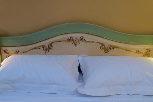 a bed with a green and white headboard and two pillows at Archontiko Leontari in Leondari