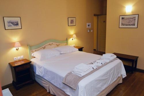 a bedroom with a white bed with towels on it at Archontiko Leontari in Leondari