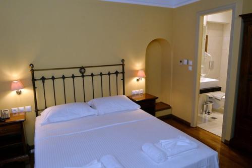 a bedroom with a large white bed with two pillows at Archontiko Leontari in Leondari