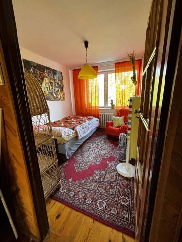 a room with a bedroom with a bed and a rug at Stylish 4BR Artist's Home with Garden- Gdańsk Green District by AVALON ATELIER in Gdańsk