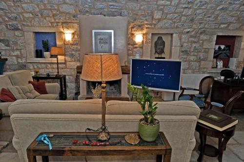 a living room with a couch and a tv at Archontiko Leontari in Leondari